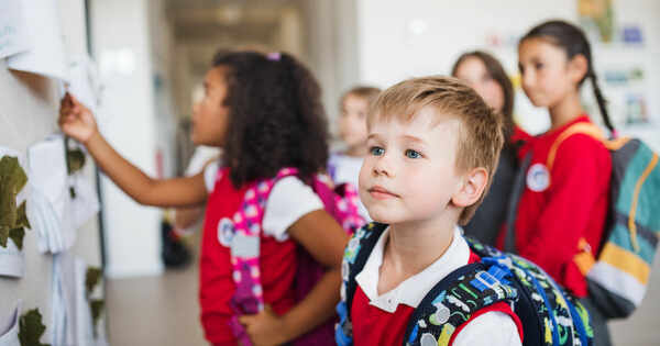 /fotos/Niños con uniforme observan el tablón de anuncios del colegio
